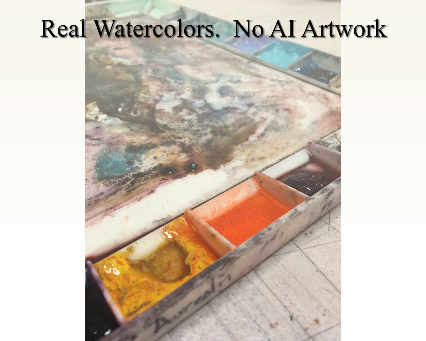Close-up of professional watercolor palette used by artist Ryan Fox, featuring rich orange, yellow, and purple pigments in well-worn mixing trays—authentic handmade watercolor art with no AI-generated content, perfect for collectors who value original, human-created artwork.